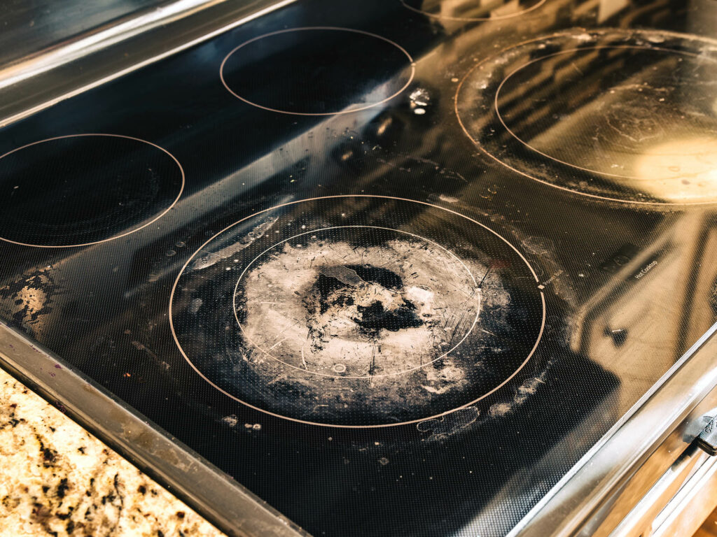 Dirty and Damaged Induction Stove in Kitchen